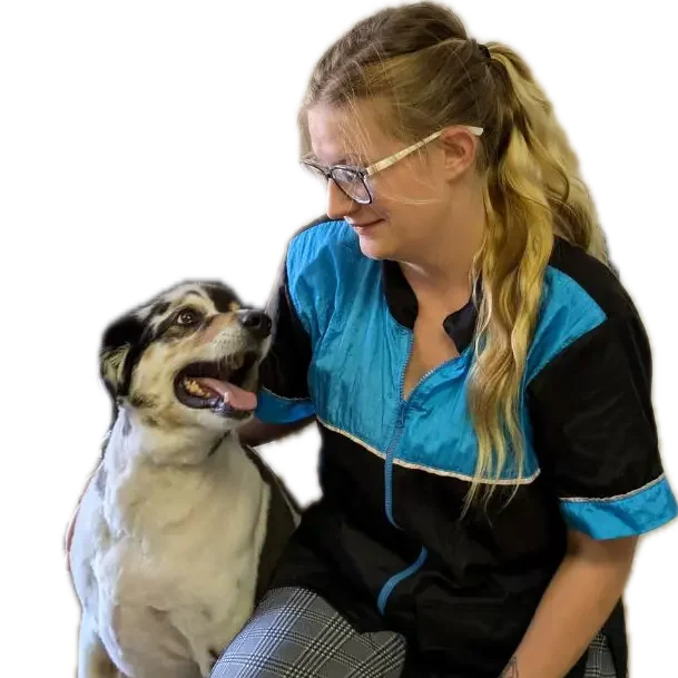 Groomer Skylar and a happy dog looking at each other